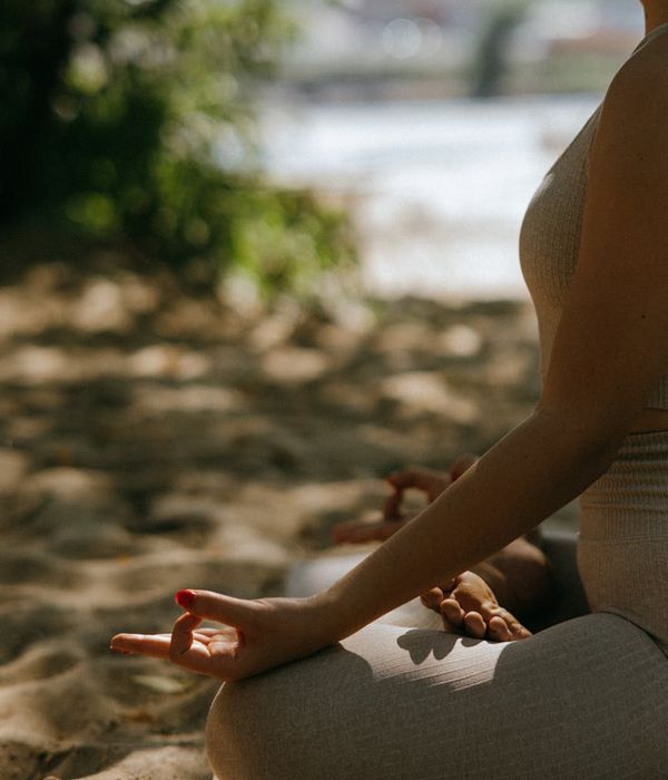 Serene woman meditating in a calm, natural environment.